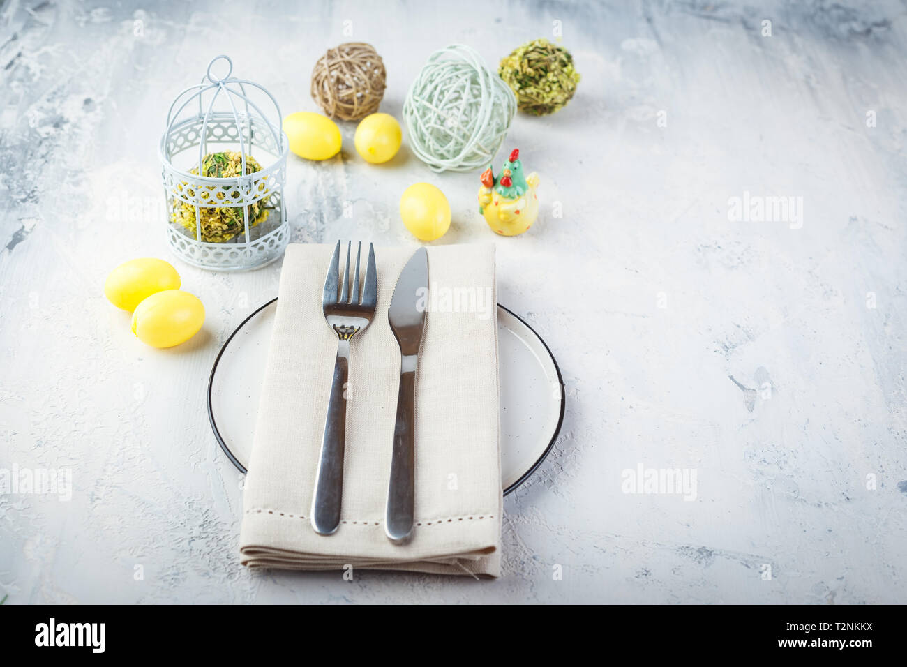Spring easter table setting with silverware, yellow easter eggs and