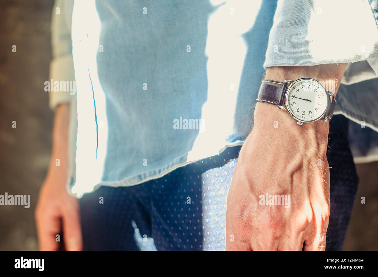 Close Up of a Men's Accessory Elegant Wrist Watches. Rolled Up Shirt Sleeves. Informal Casual Wear Concept Stock Photo