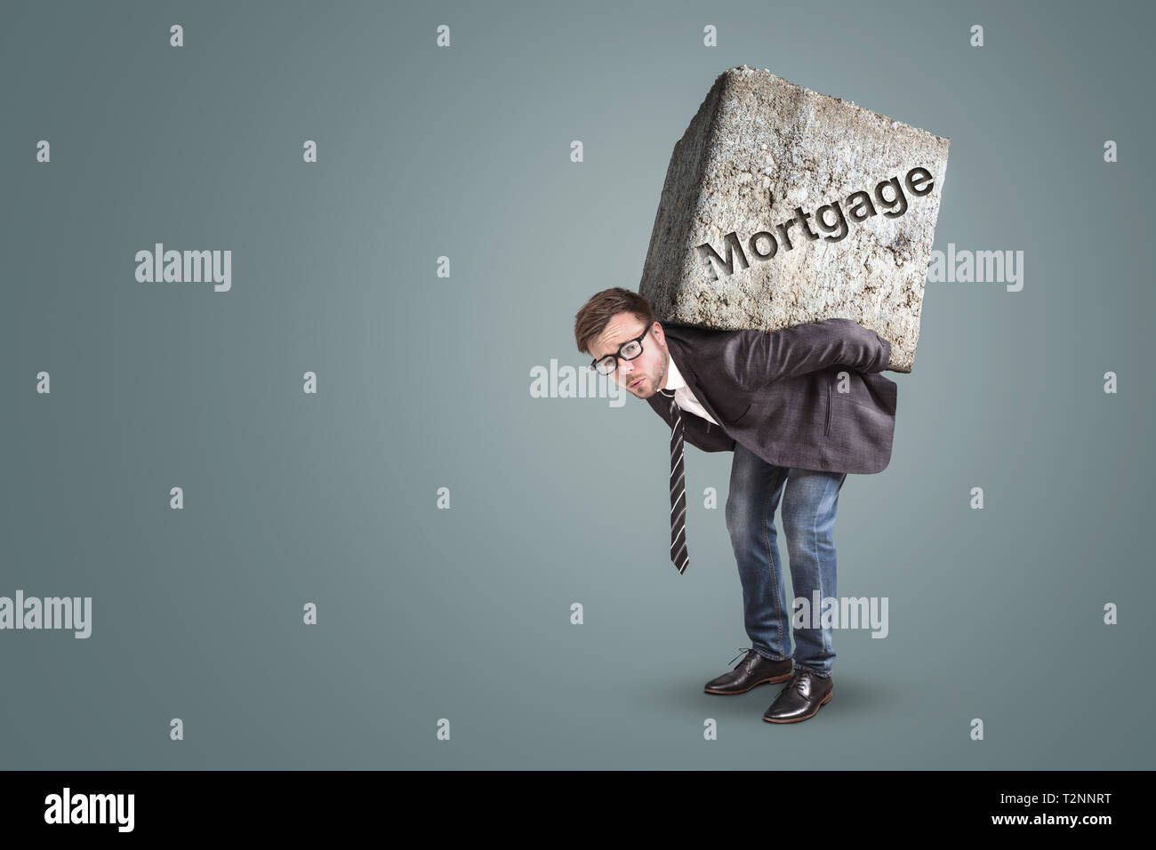 Concept of a man carrying a large stone with the word “Mortgage” on it Stock Photo