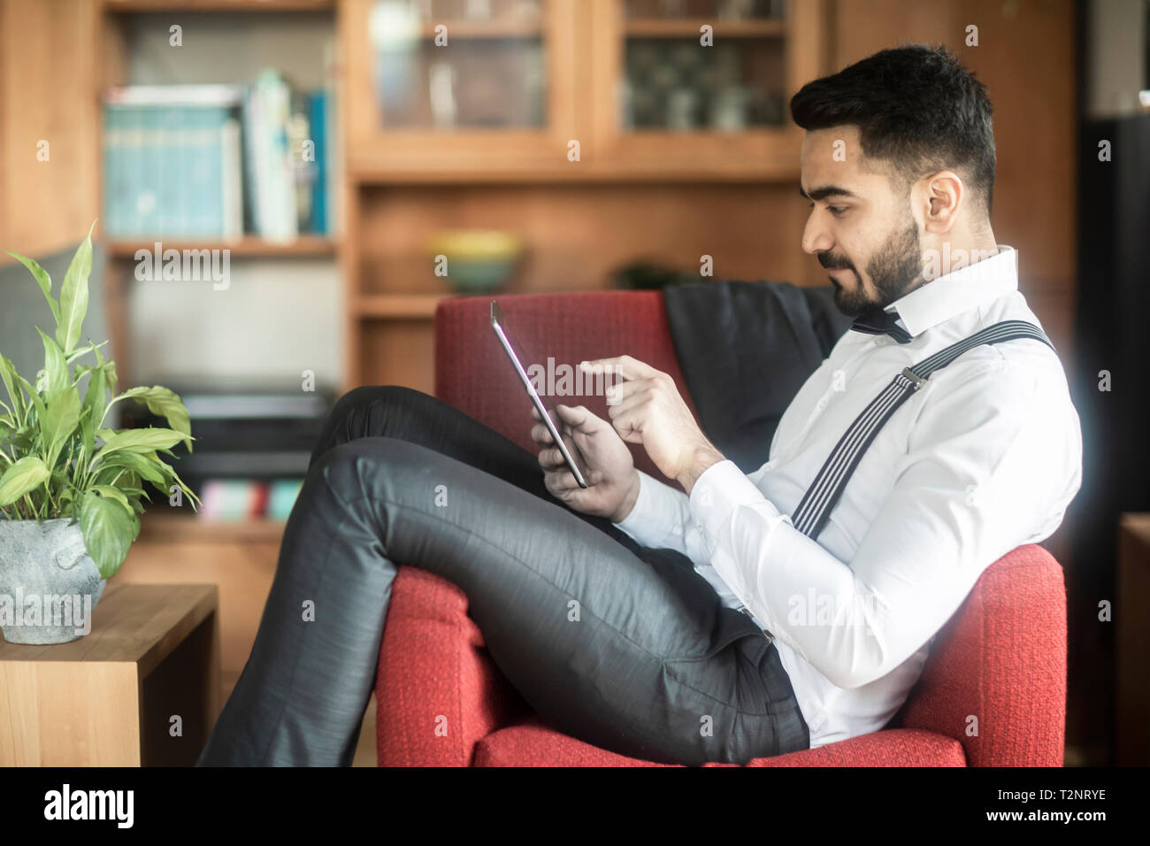 Businessman using digital tablet in armchair Stock Photo