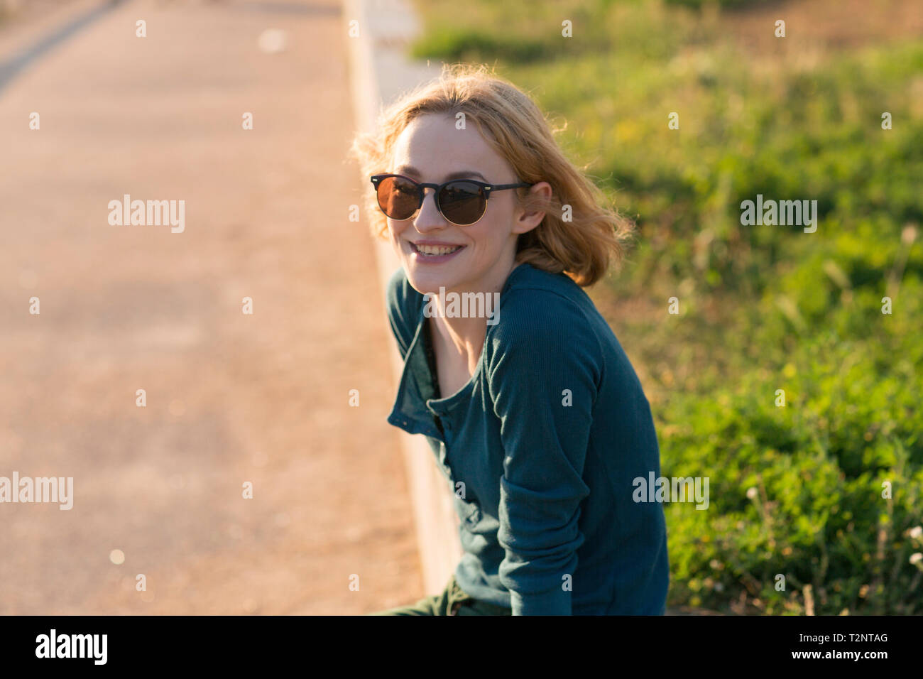 Young woman relaxing in park by river in summer Stock Photo