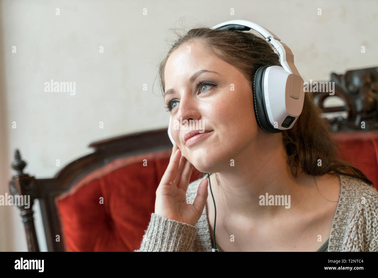 Young woman listening to music with headphones at home Stock Photo