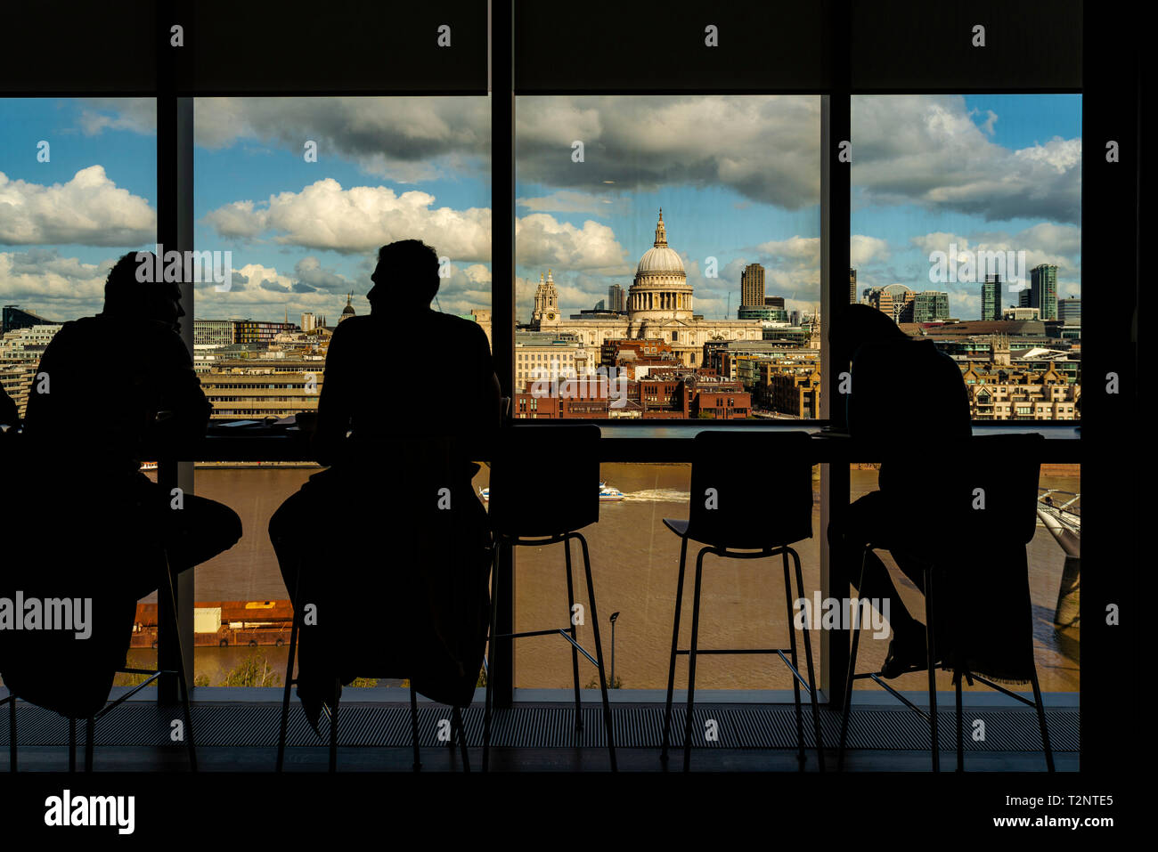Silhouette of people having conversation by glass window, St Paul's Cathedral in background, City of London, UK Stock Photo