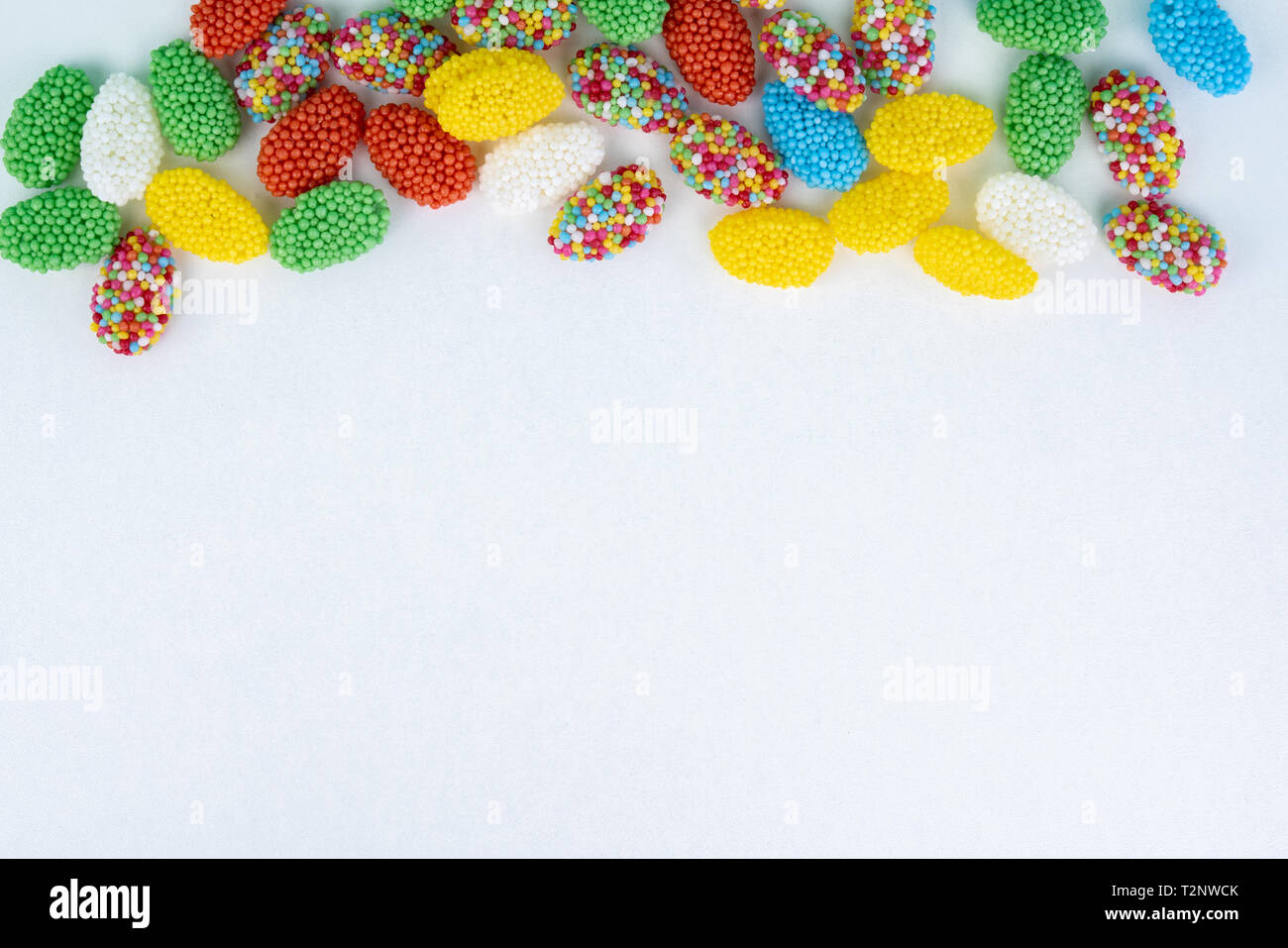 Top view of colored candy on a white background with space next to it ...