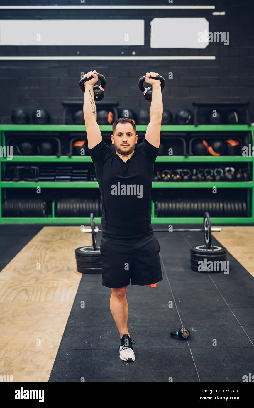 Man with disability using kettlebells in gym Stock Photo