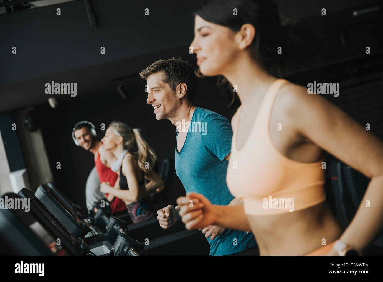 Group of young people running on treadmills in modern gym Stock Photo ...