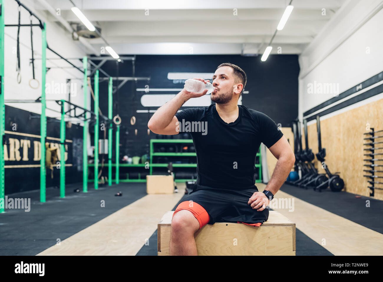 Man with disability drinking water in gym Stock Photo