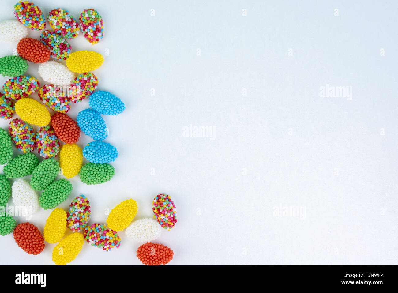 Top view of colored candy on a white background with space next to it ...