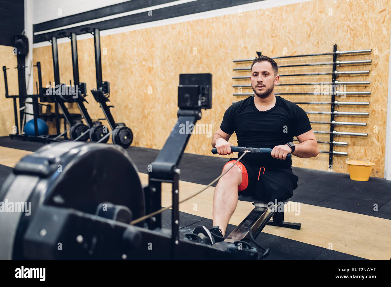 Man with disability using rowing machine in gym Stock Photo
