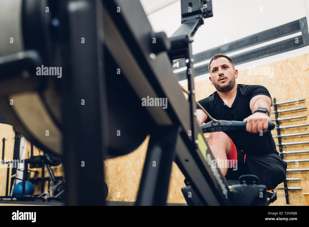 Man with disability using rowing machine in gym Stock Photo