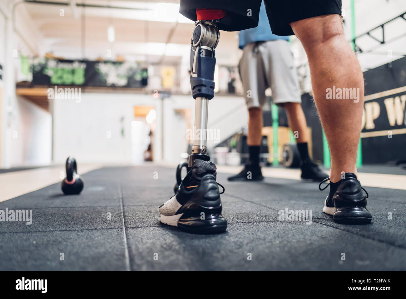 Man with prosthetic leg and friend in gym Stock Photo