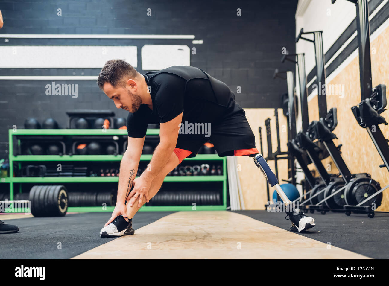 Man with prosthetic leg stretching in gym Stock Photo