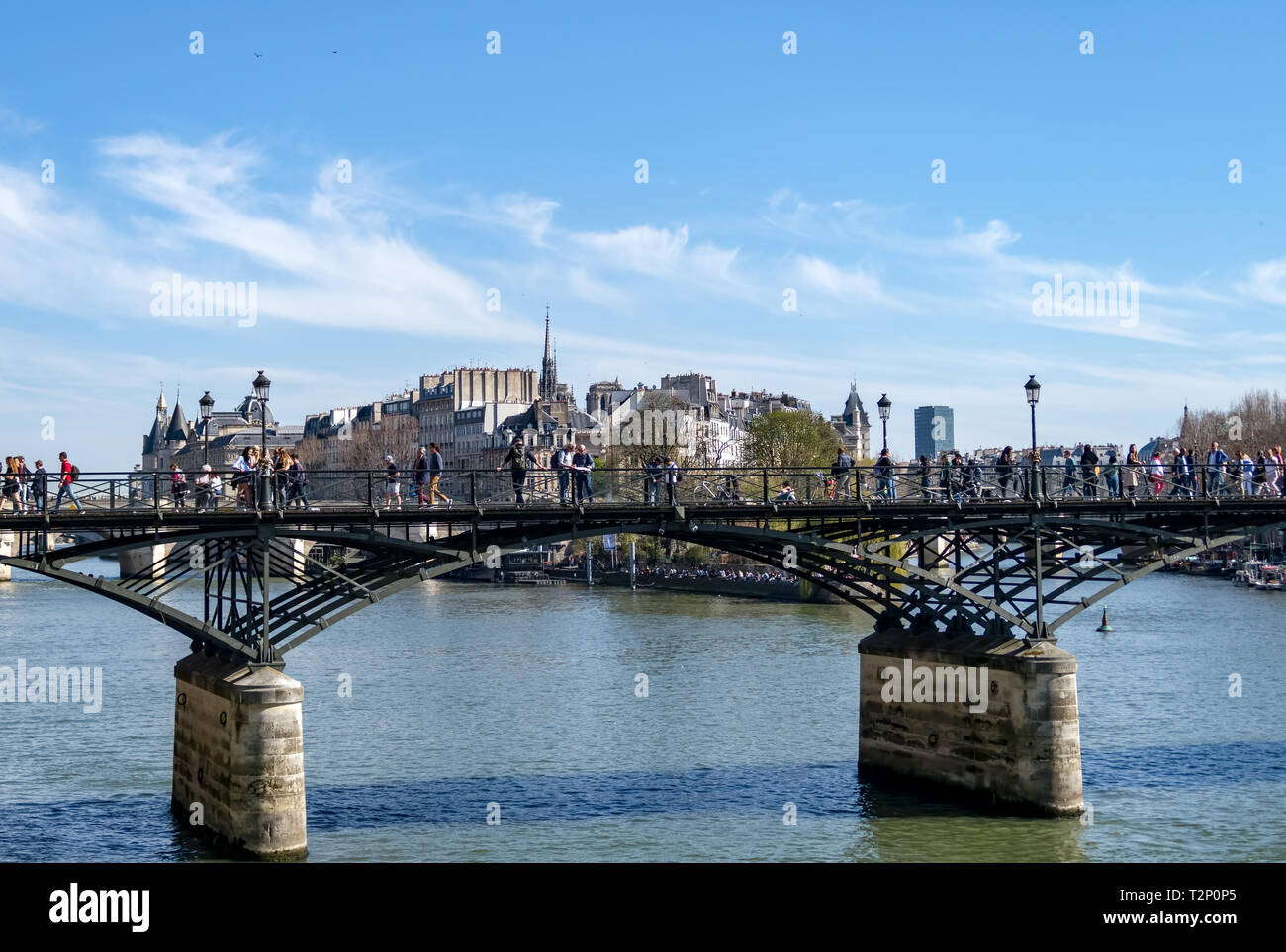 People walking on Pont des Arts bridge on the Seine river - Paris Stock Photo