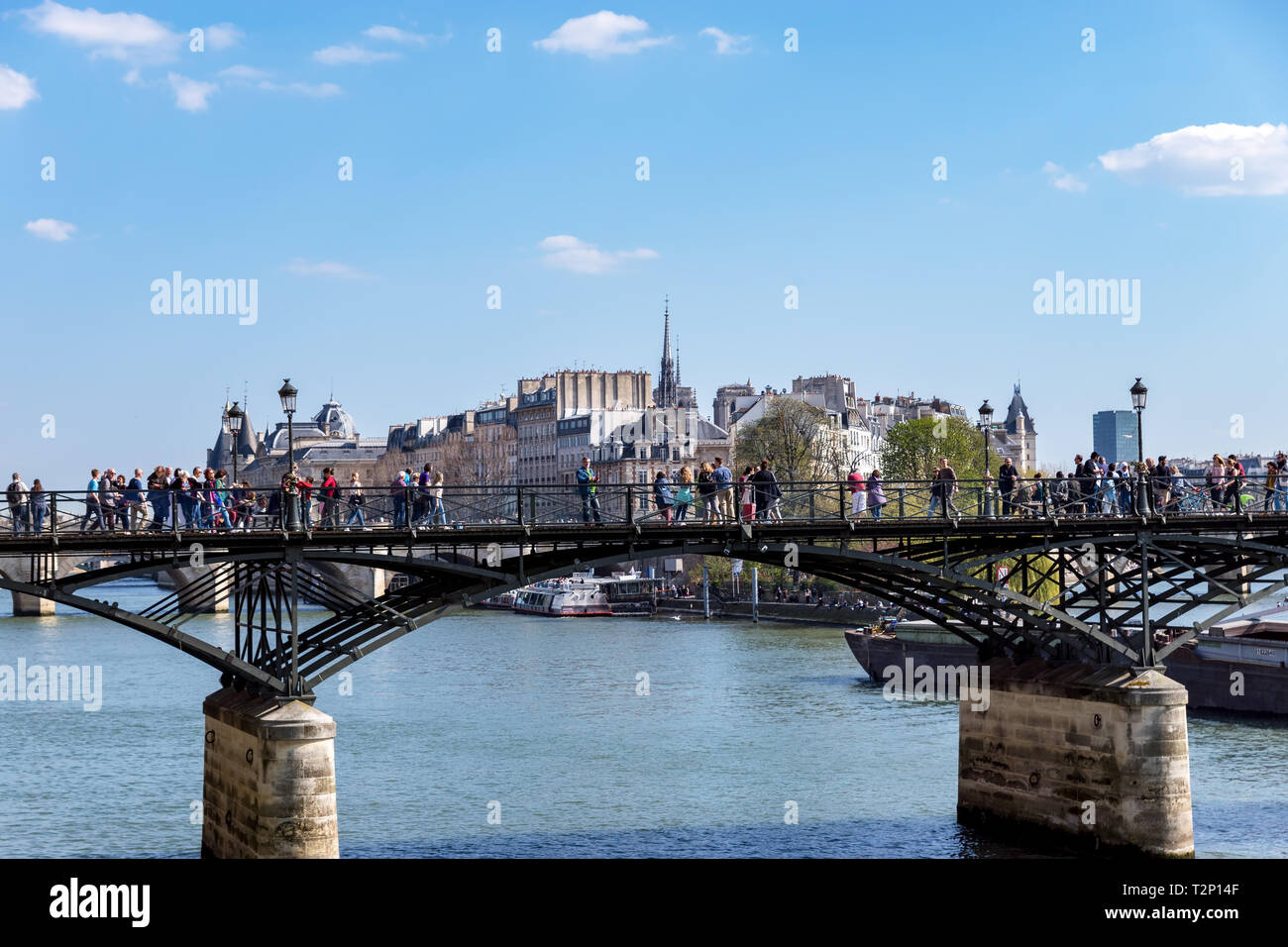 People walking on Pont des Arts bridge on the Seine river - Paris Stock Photo