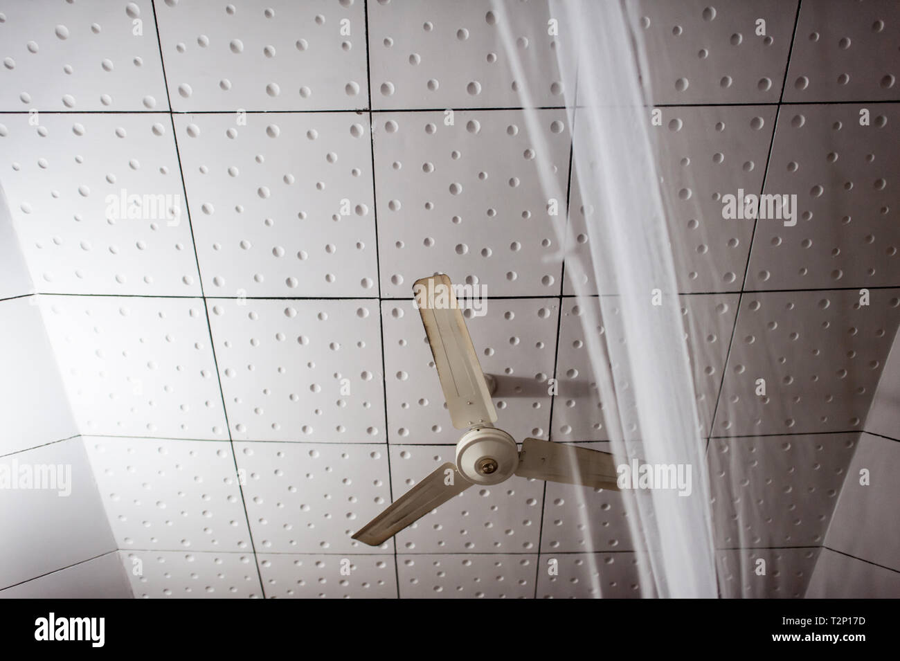 A mosquito net and ceiling fan, much like you will find right across India, Asia and many hot and humid countries. Stock Photo