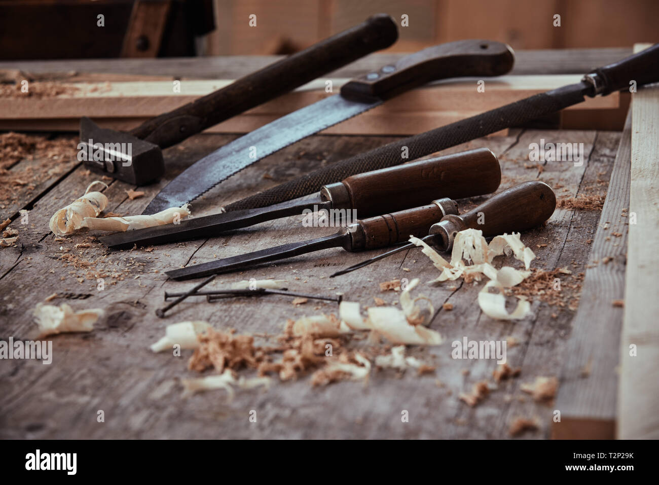 Vintage chisels, rasp, handsaw and hammer on a woodworking workbench ...