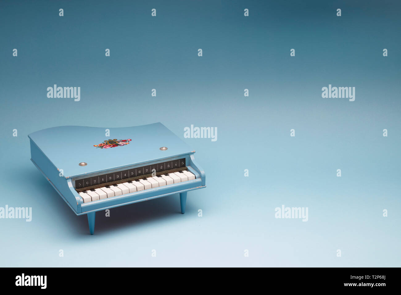 Toy grand piano on a blue background Stock Photo
