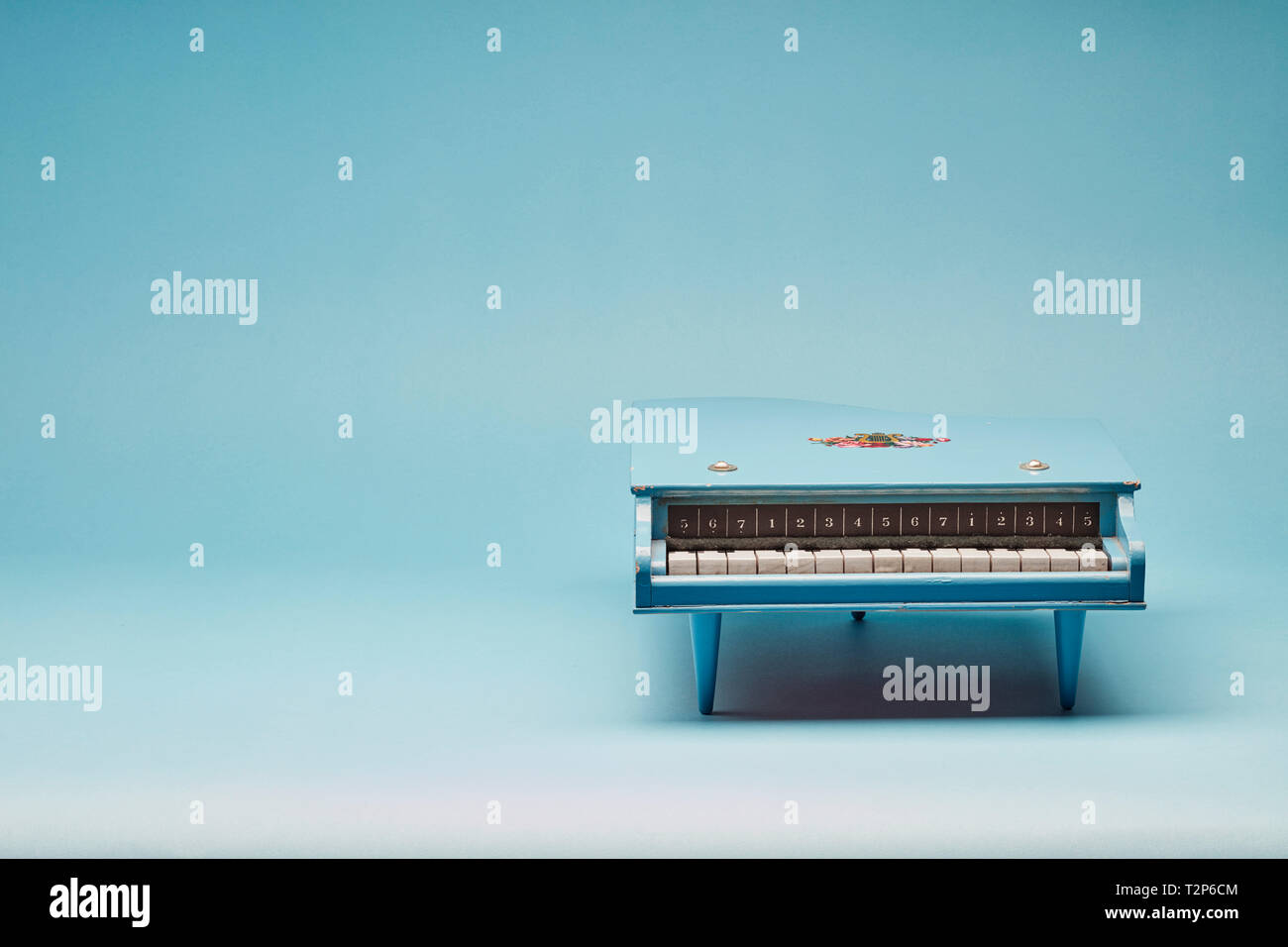 Toy grand piano on a blue background Stock Photo