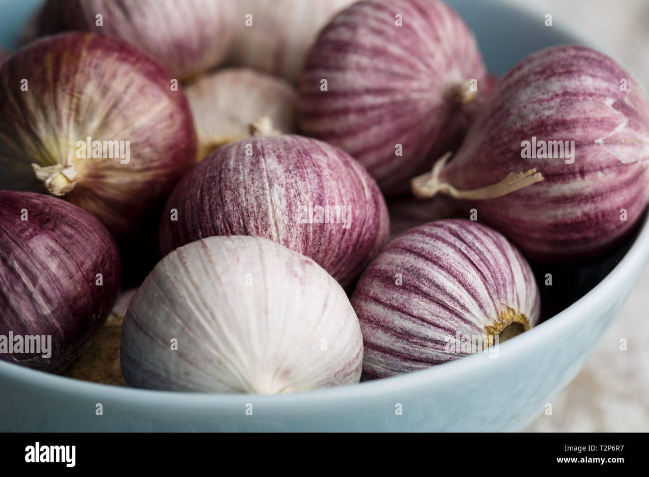 Whole Bulbs of Chinese Garlic in blue bowl Stock Photo