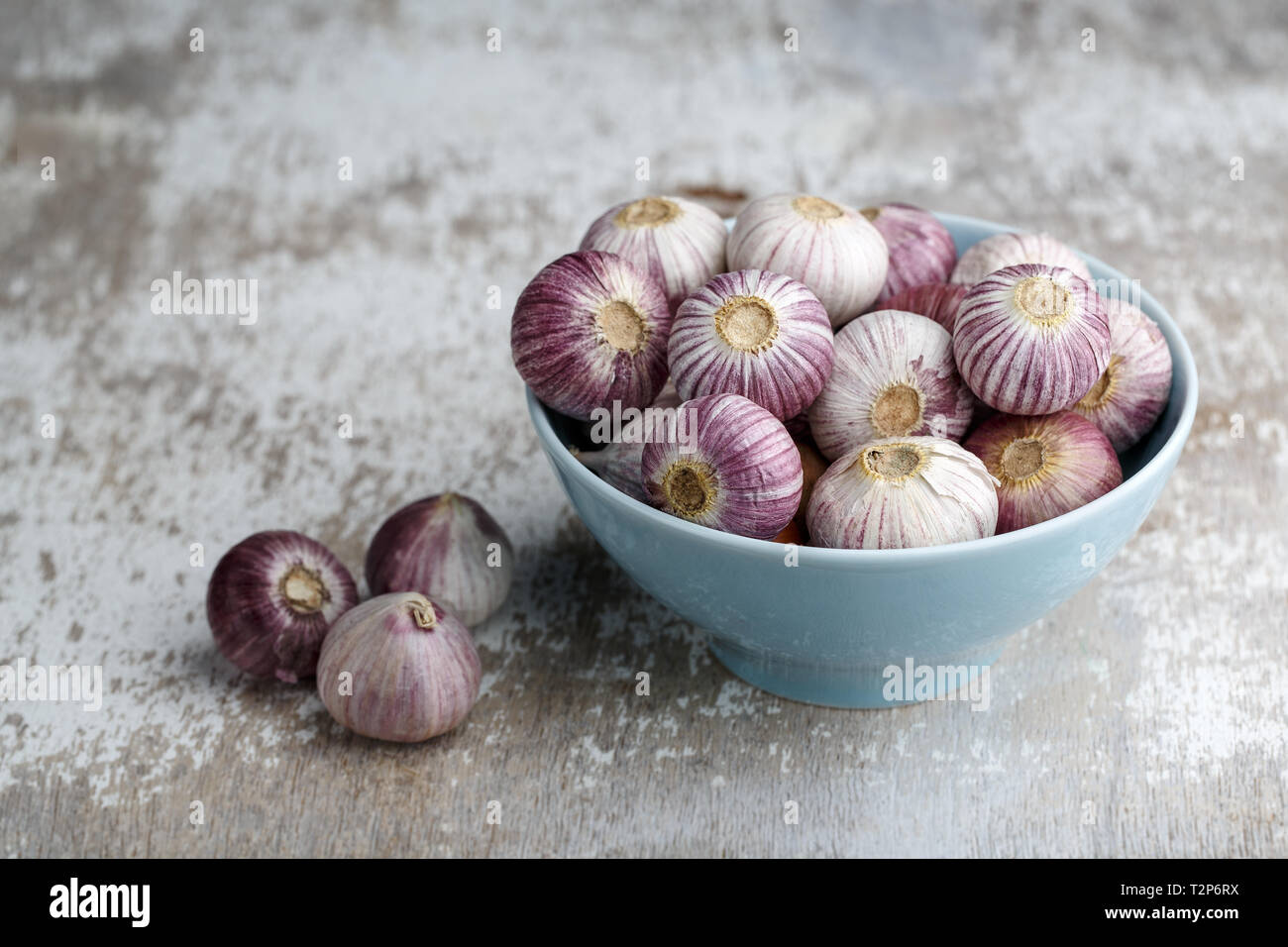 Whole Bulbs of Chinese Garlic in blue bowl Stock Photo