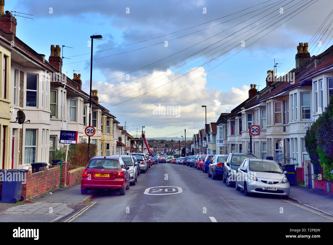 Looking down street of terraced bay windowed suburban houses in Filton with 20 mph speed signs, suburb of Bristol, England, UK Stock Photo