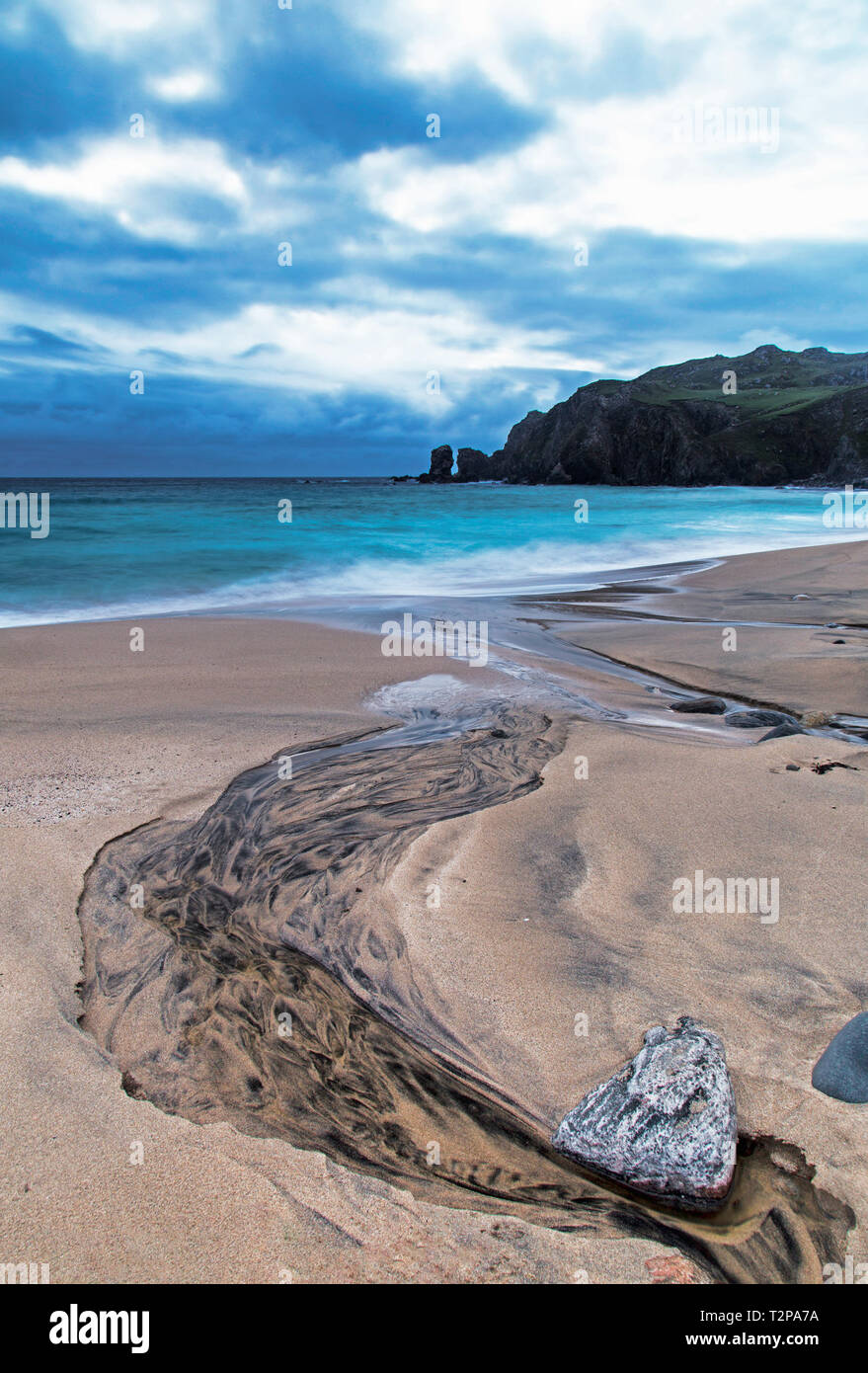The black river runs down to Dalmore beach on the Isle of Lewis Stock Photo