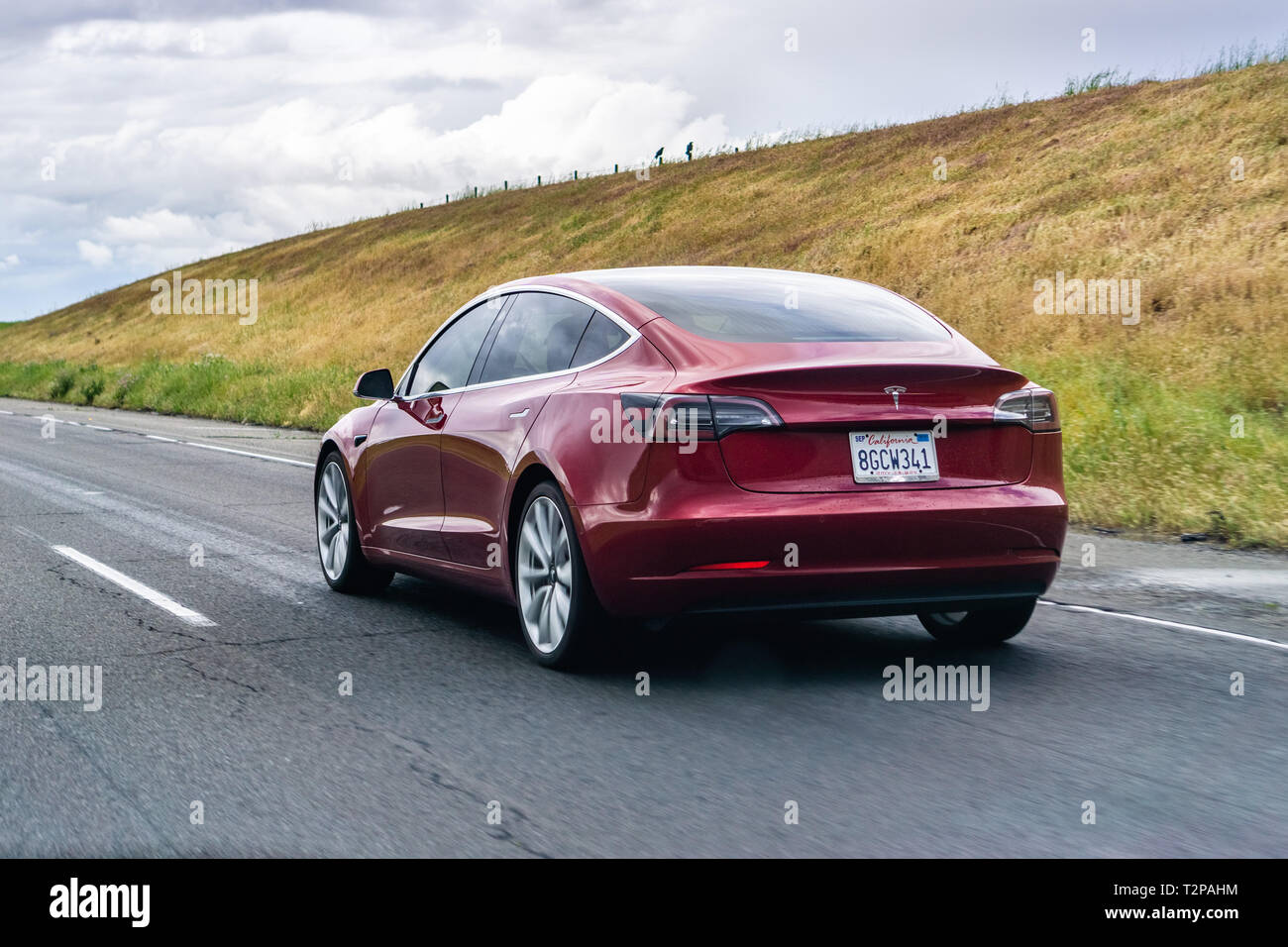 March 20, 2019 Los Angeles / CA / USA - Red Tesla Model 3 driving on the freeway Stock Photo