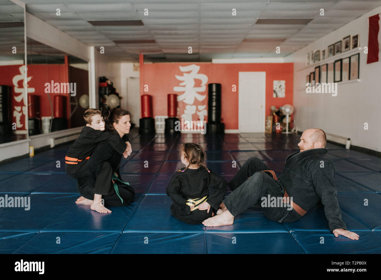 Coaches and students resting in martial arts studio Stock Photo