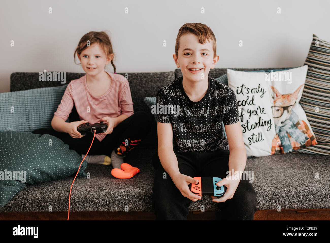 Children playing video game on couch Stock Photo Alamy