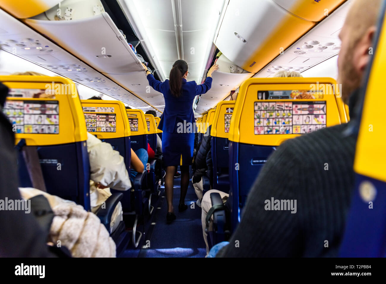 Airplane passenger walking aisle hires stock photography and images