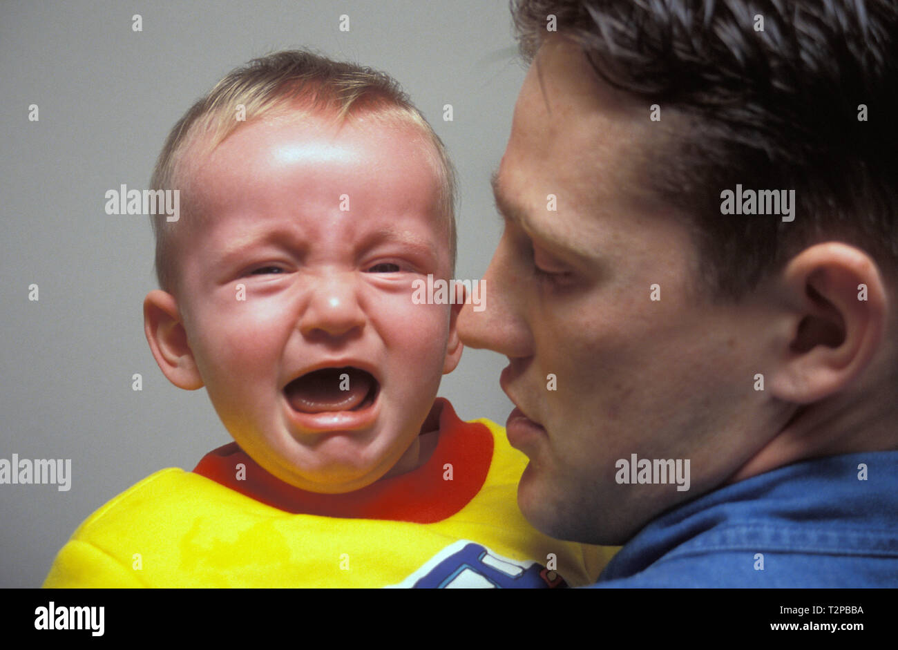 father holding screaming baby boy Stock Photo