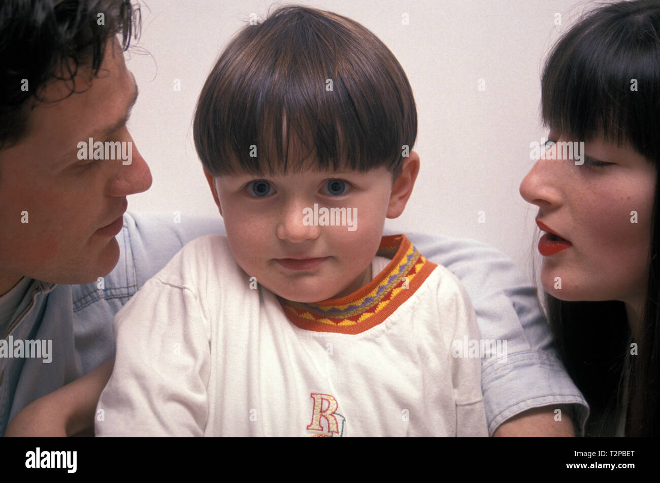 cheeky little boy between his two parents Stock Photo