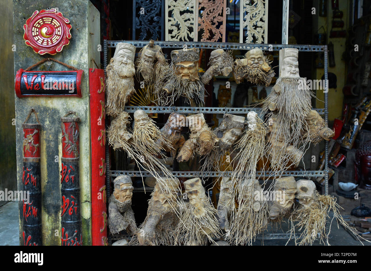 Hoi An, Vietnam - December 20th 2017. Souviners for sale outside a tourist shop in Hoi An. These are plant and tree roots carved with faces Stock Photo