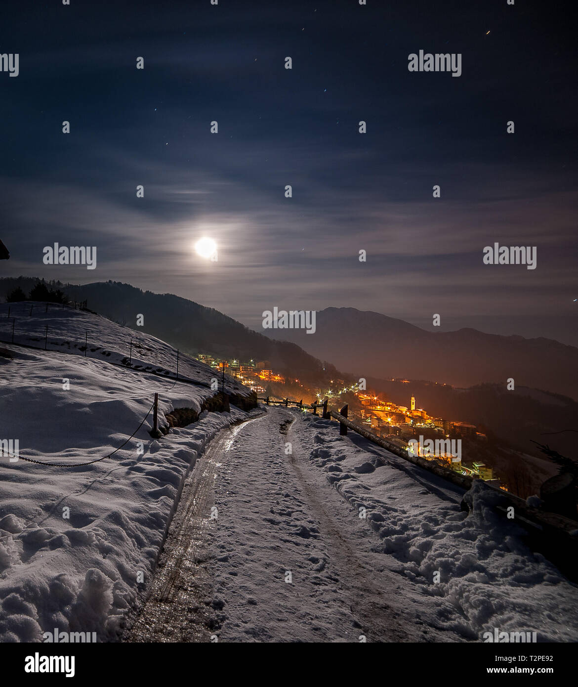 snowy mountain village at night with the moon Stock Photo - Alamy