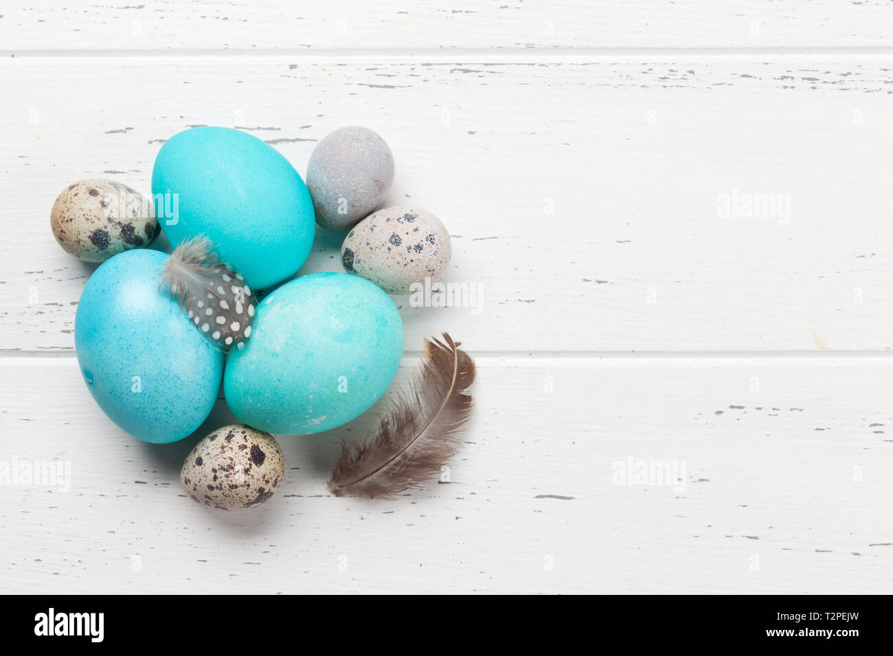 Easter greeting card with colorful eggs. Top view on wooden table with ...