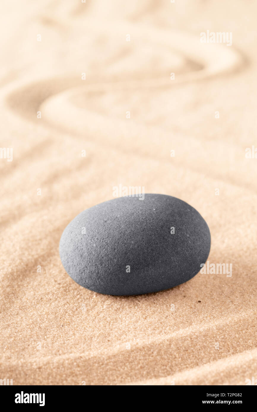 round stone on sand with line. Zen meditation or spa wellness background. Japanese sandy garden. Stock Photo