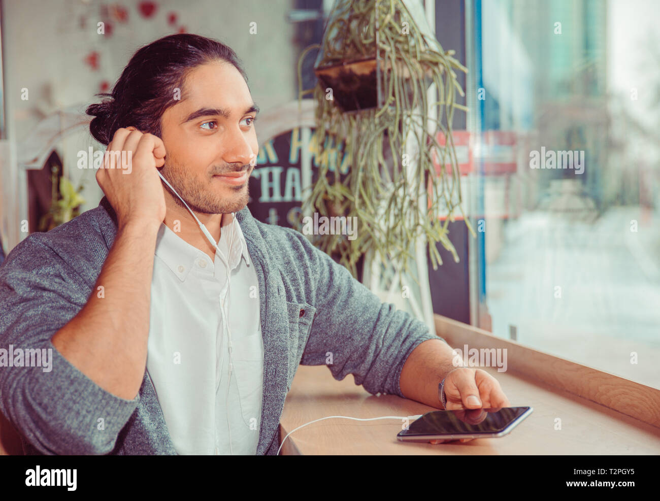 Man listening to audio book near a window at home. Closeup portrait of