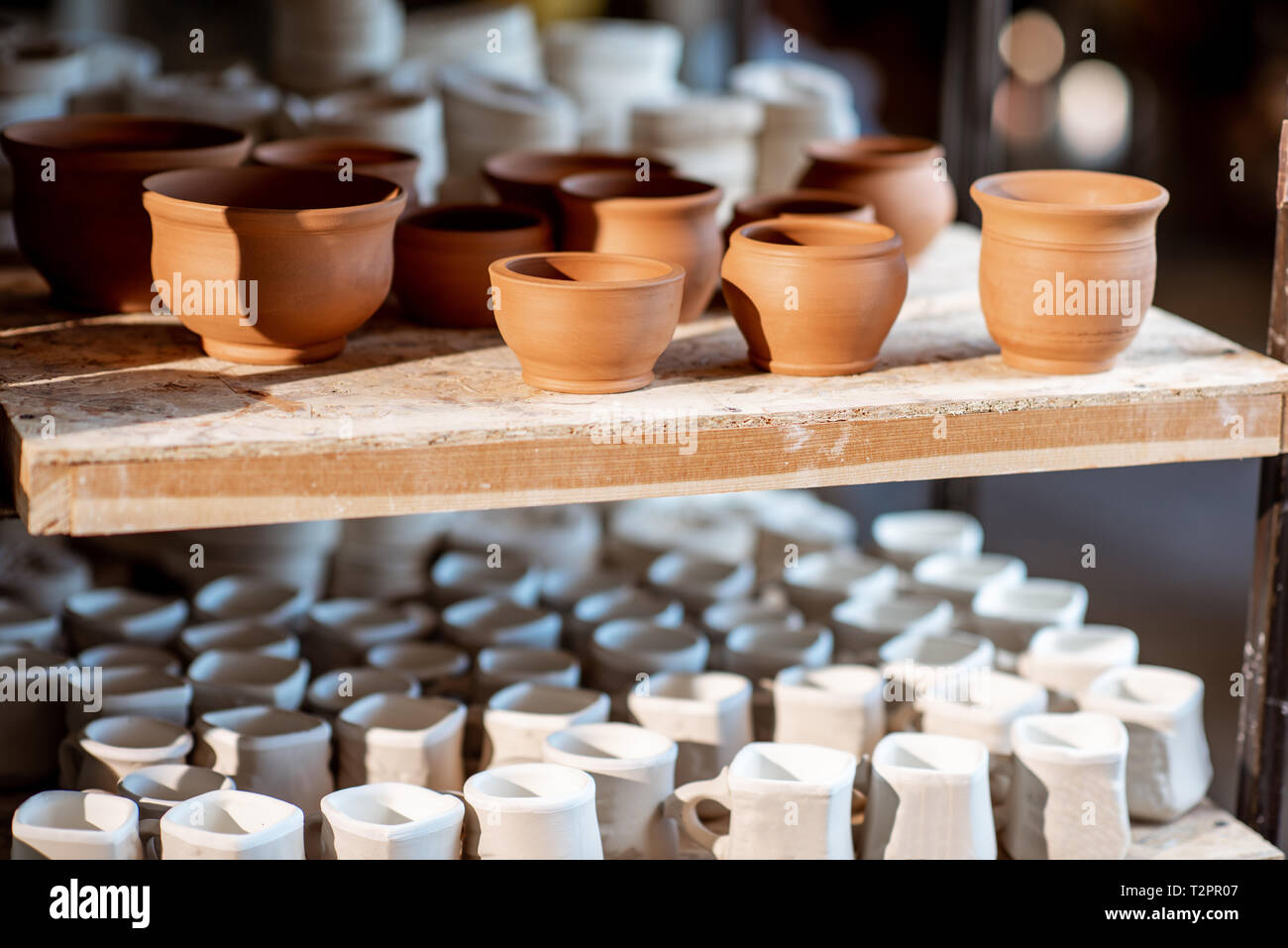 Close-up of clay pitchers before baking on the shelves at the pottery Stock Photo