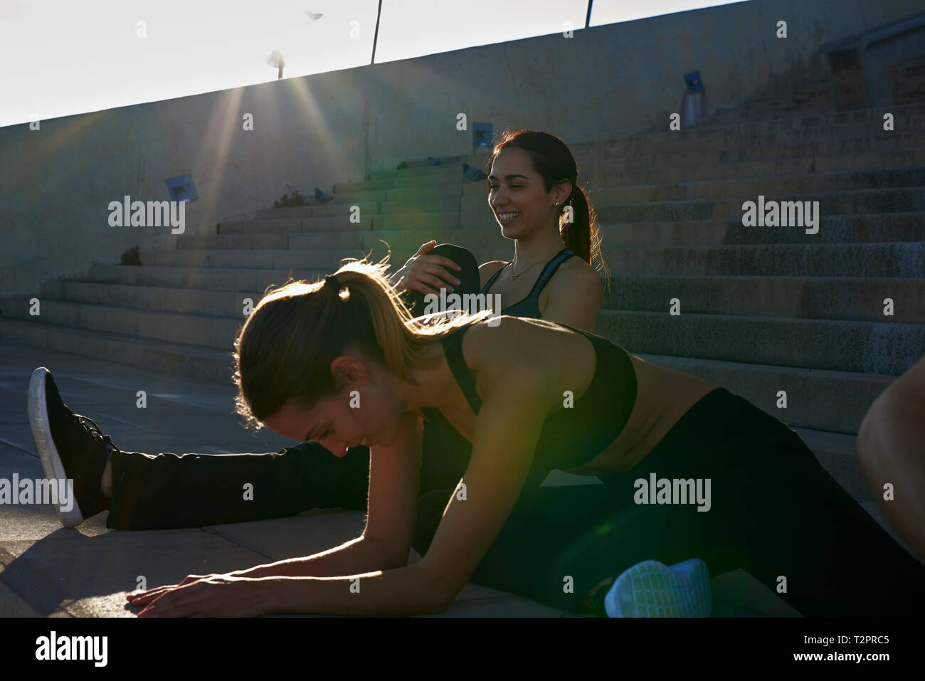 Friends stretching on steps in sports stadium Stock Photo