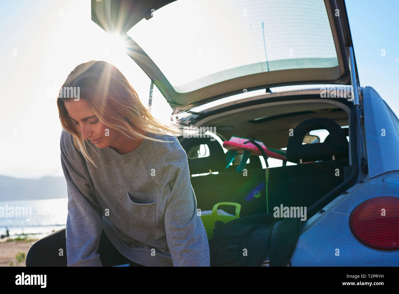 Young woman standing behind open car boot Stock Photo