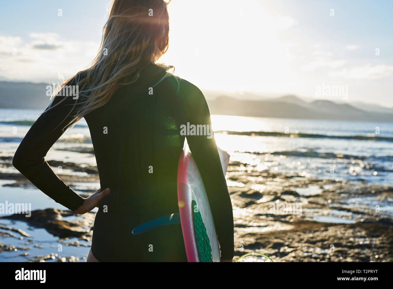 Surfer with surfboard on beach Stock Photo