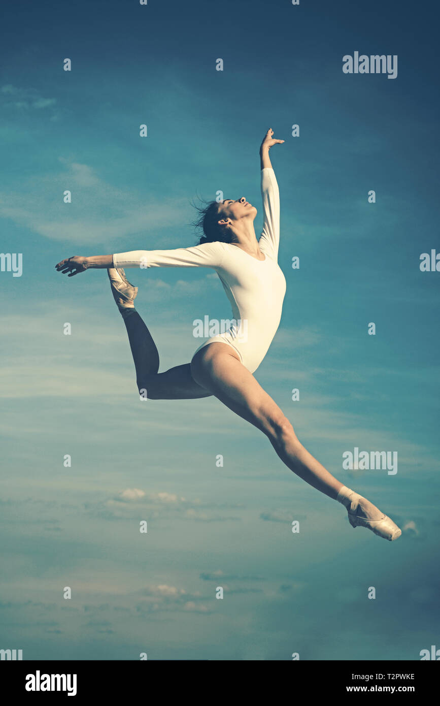 Grace in every move. Practicing art of classical ballet. Ballerina jumping on blue sky. Cute ballet dancer. Pretty woman in dance wear. Ballet class.  Stock Photo