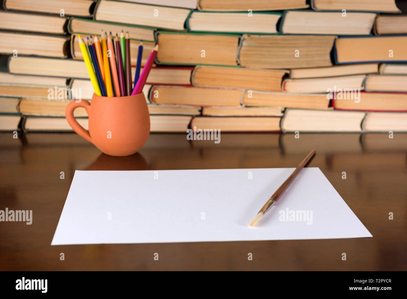 Paper and pencils on the wooden table, books background Stock Photo
