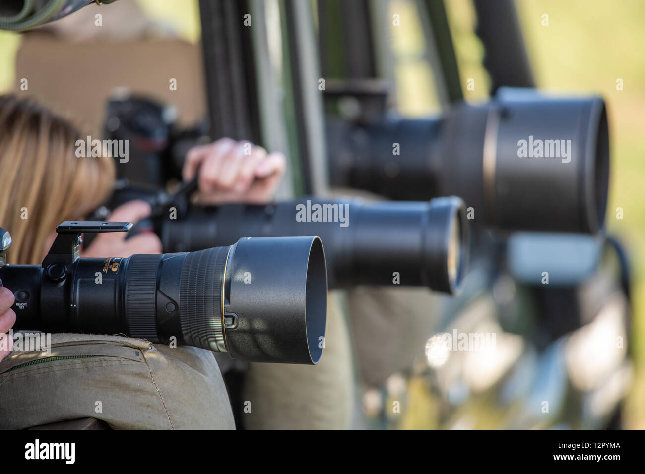 Photographers ready their cameras with lenses lined up in action at