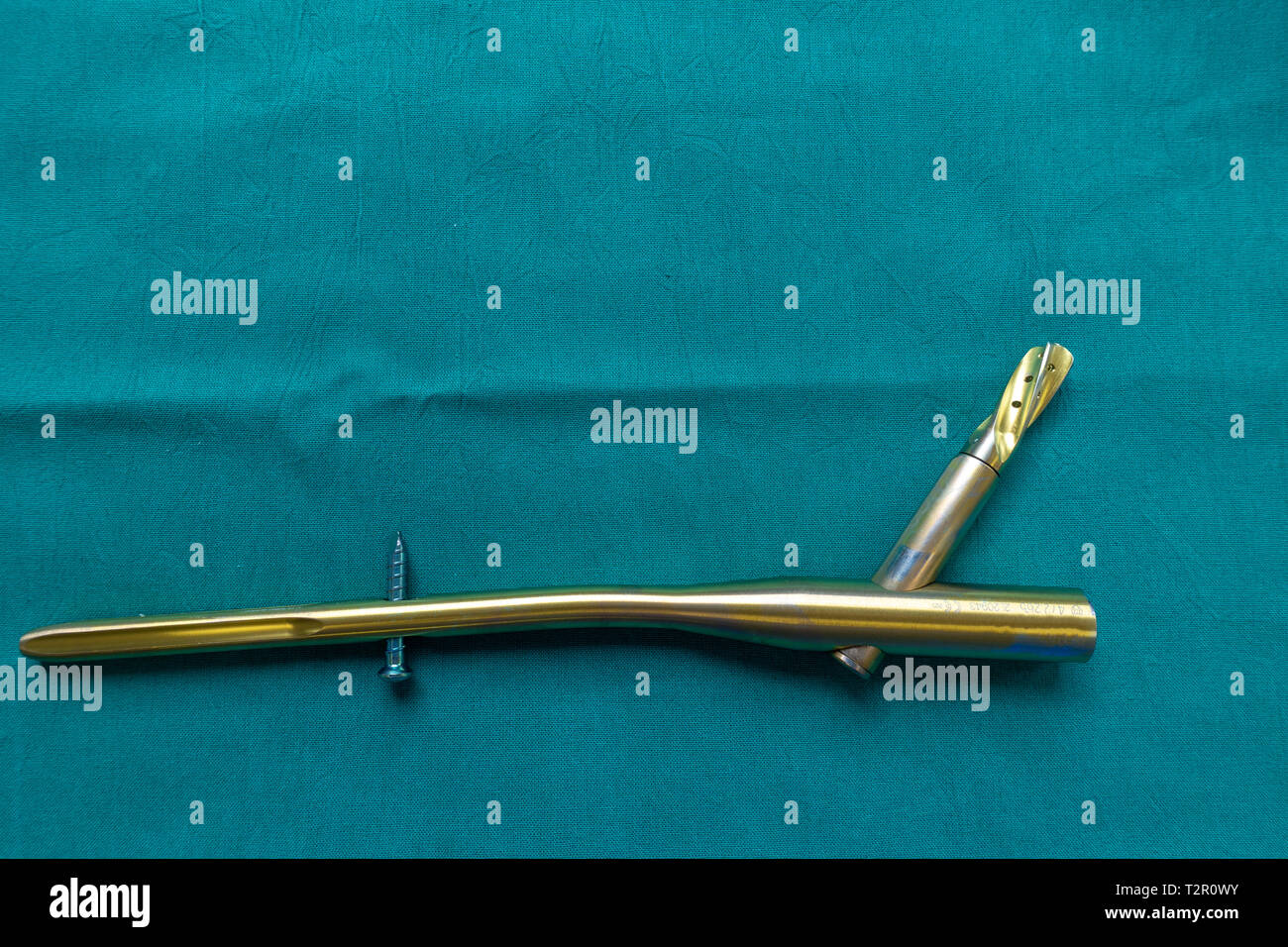 an explanted titanium femur nail on a green surgical drape Stock Photo