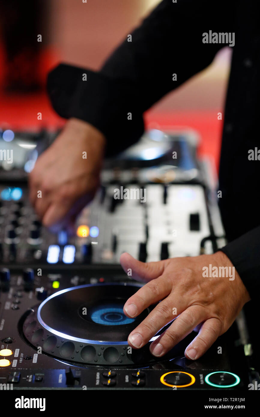 Disk jockey playing music at mixer Stock Photo Alamy