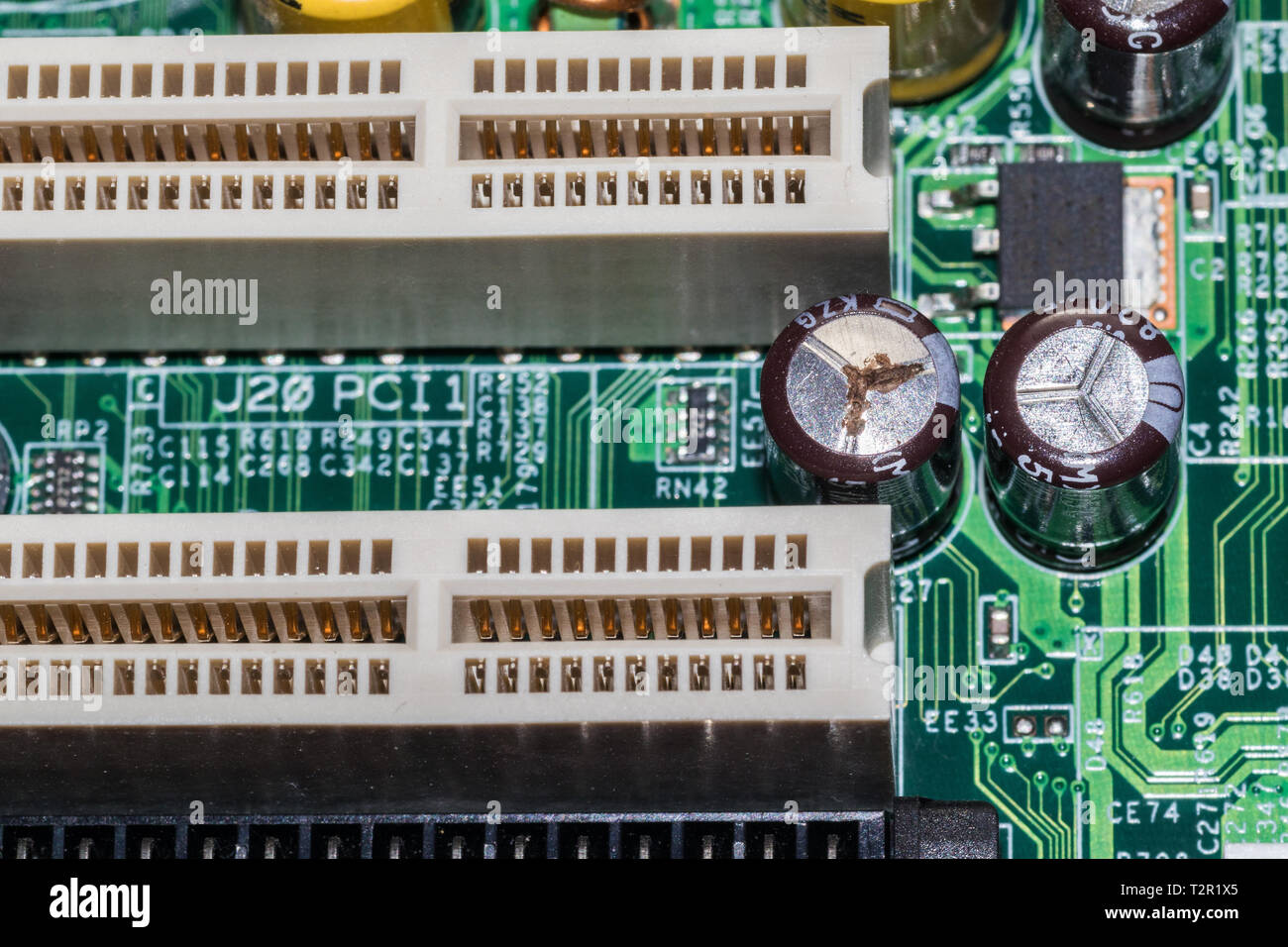 The photo shows a capacitor on a motherboard that has gone bad. It is  visibly bulging at the top, and seems to be leaking as well as corroded  Stock Photo - Alamy