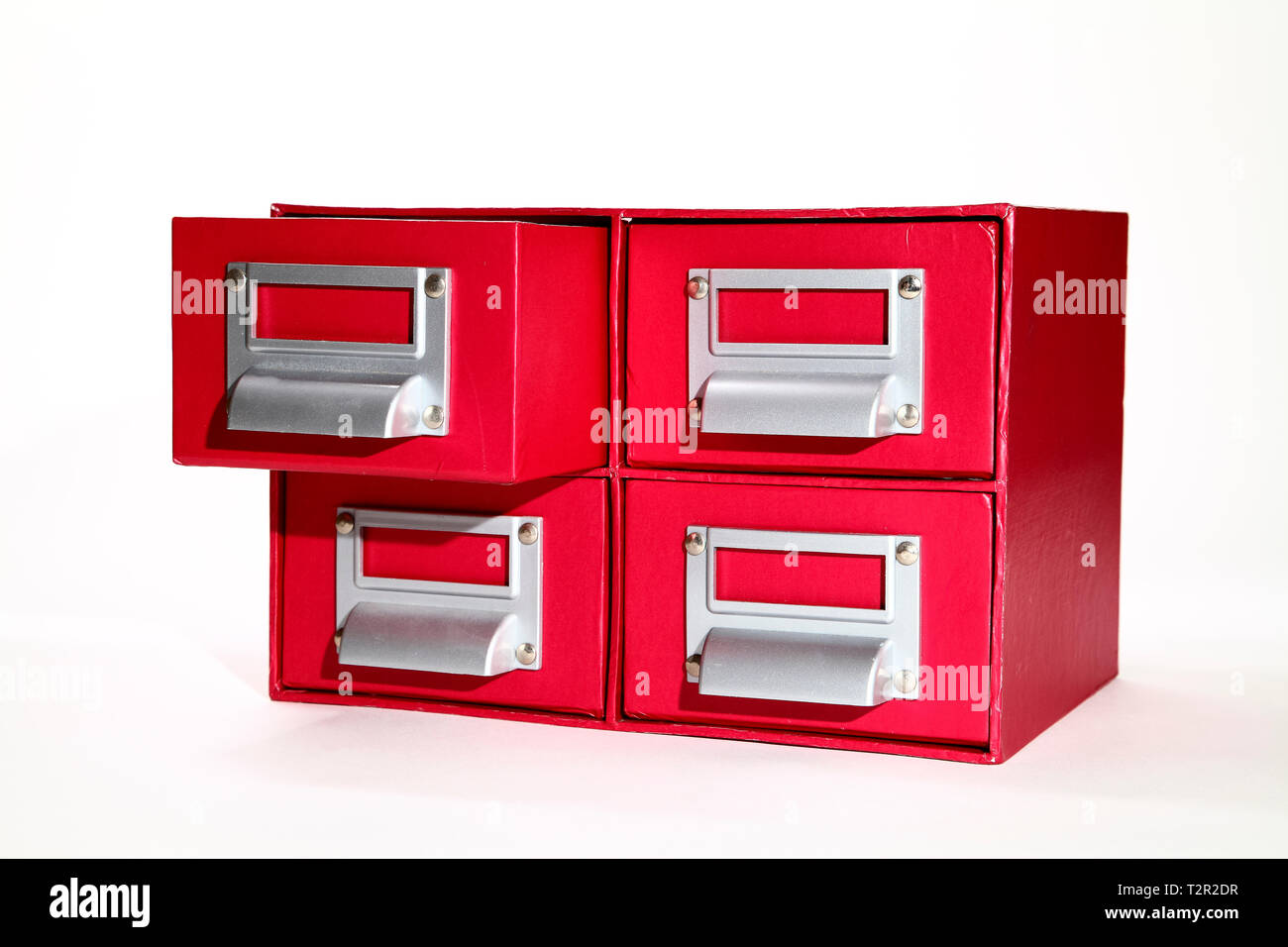 red filing cabinet with one draw open isolated on a white background Stock Photo
