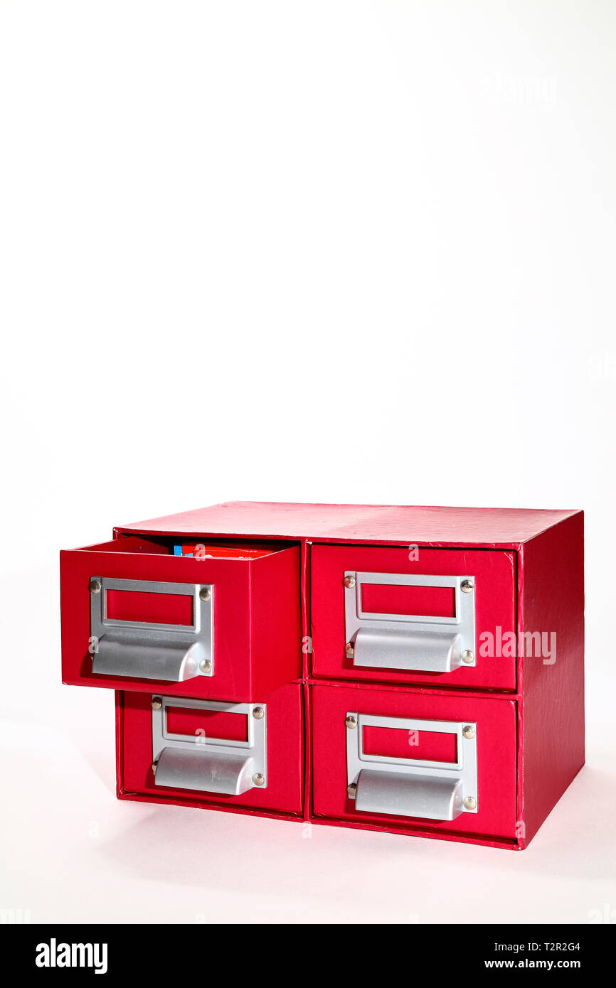 red filing cabinet with one draw open isolated on a white background Stock Photo