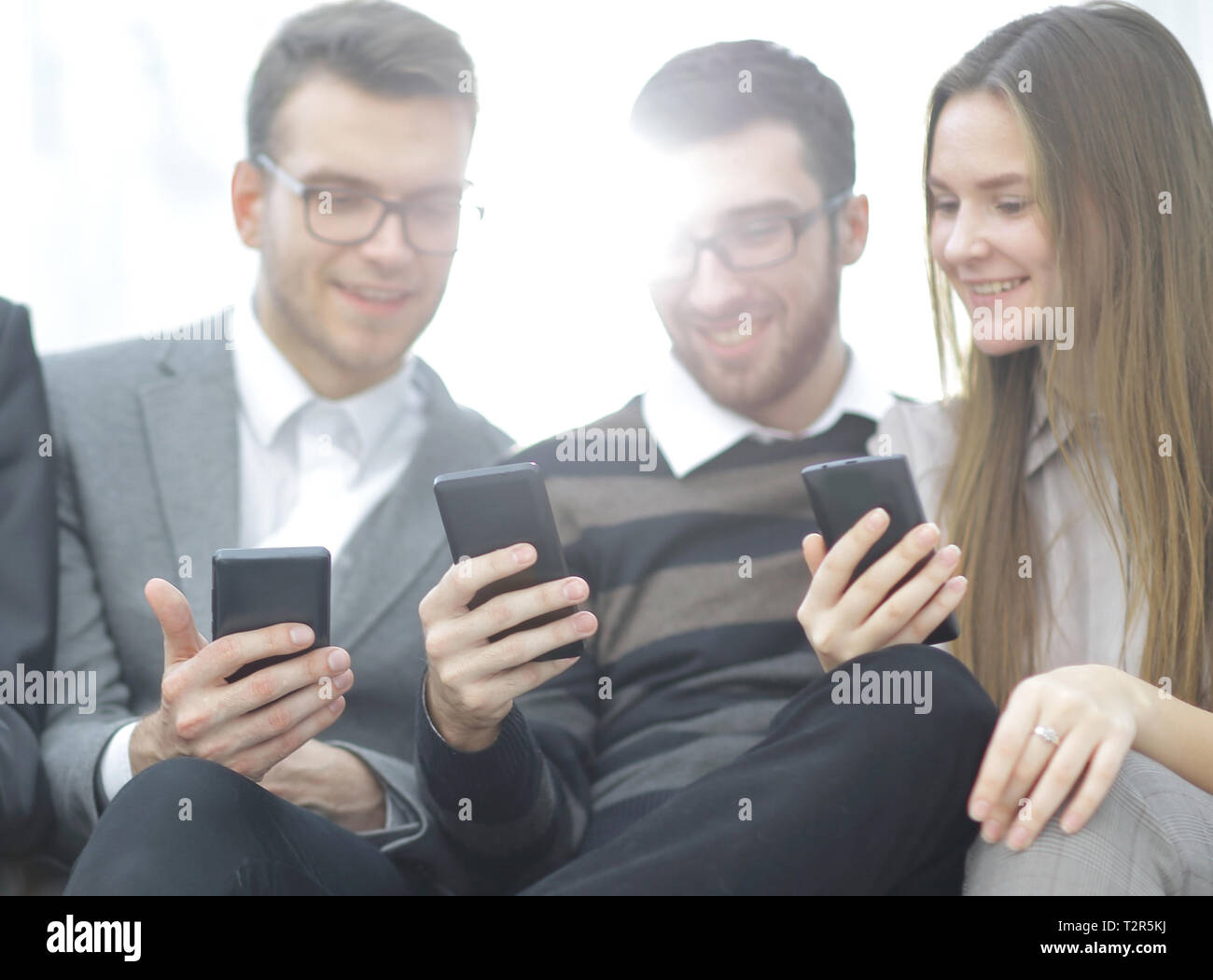 close up.the business team uses their smartphones sitting in the lobby ...